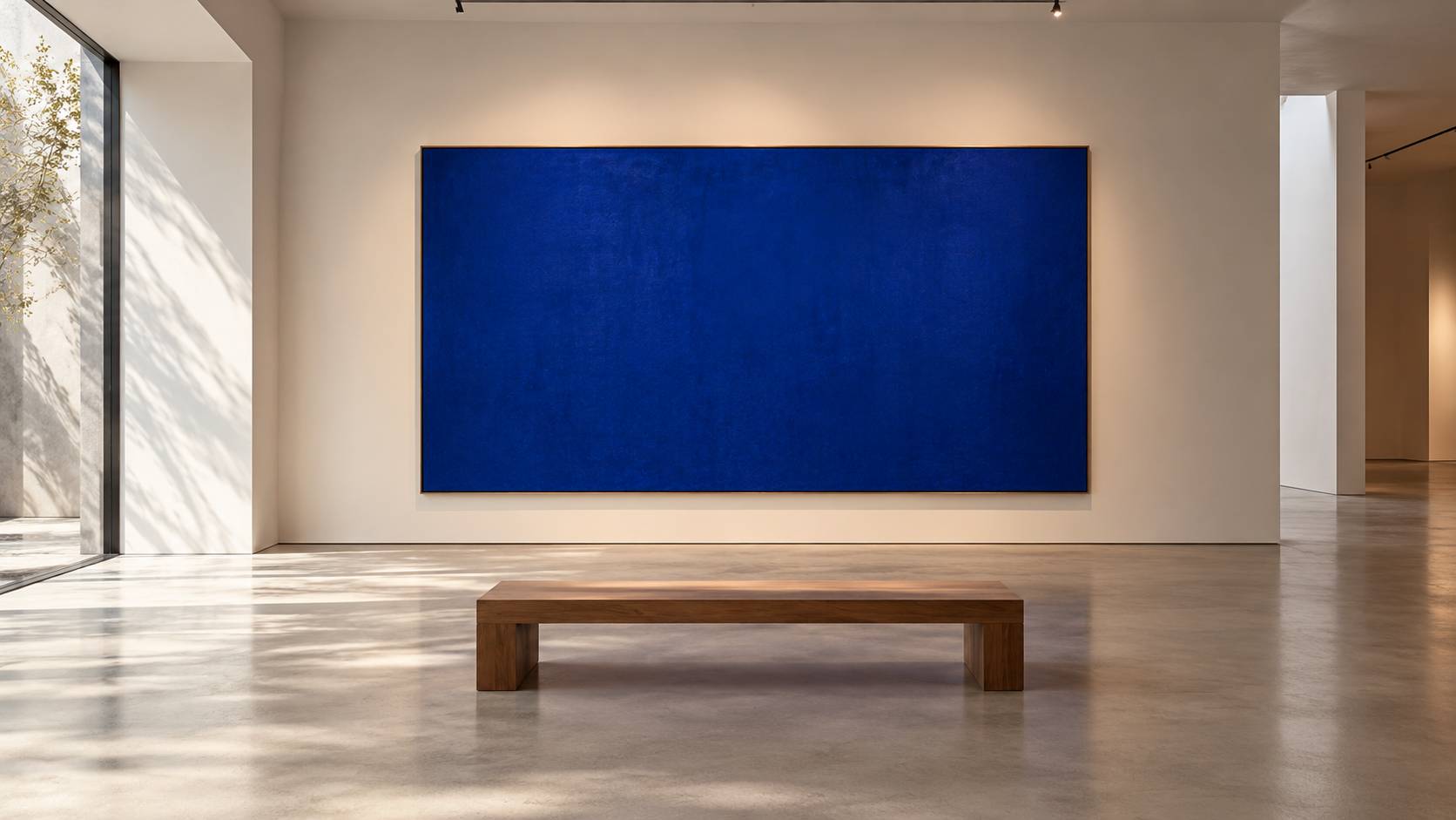 Toile monochrome bleu profond encadrée sur un mur de galerie éclairé